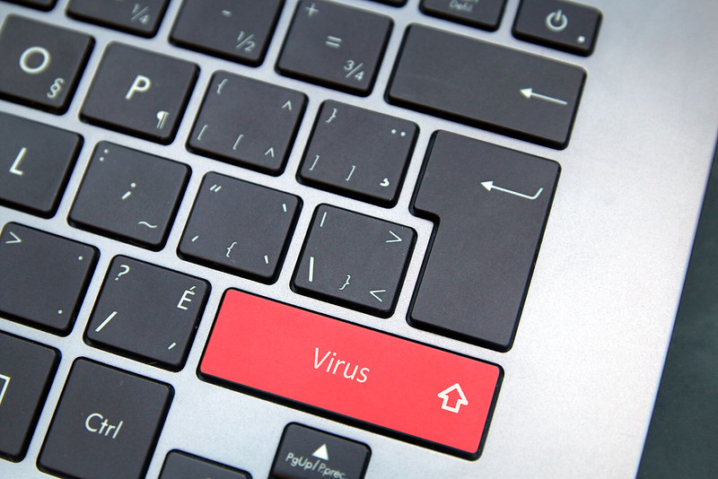 Cyber security virus written on laptop keyboard